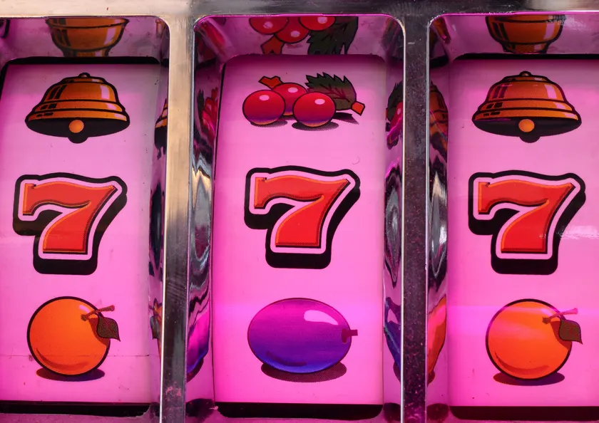 Classic slot machine reels with lucky sevens, bells and cherries, typical of online slot games in Malaysia